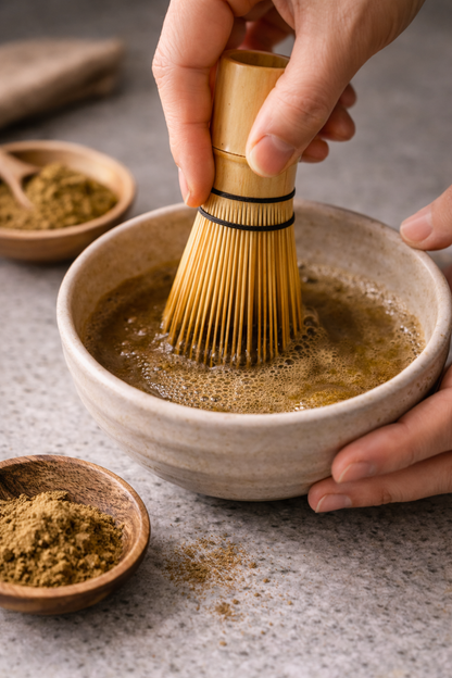 Person whisking hojicha roasted green tea powder in a ceramic bowl