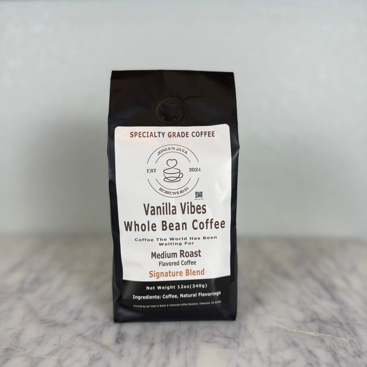 Vanilla Vibes whole bean coffee medium roast flavored coffee bag by Jones’N Java on marble countertop