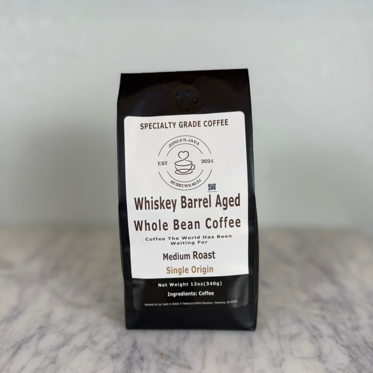 Whiskey barrel aged whole bean coffee medium roast single origin coffee bag by Jones’N Java on marble countertop