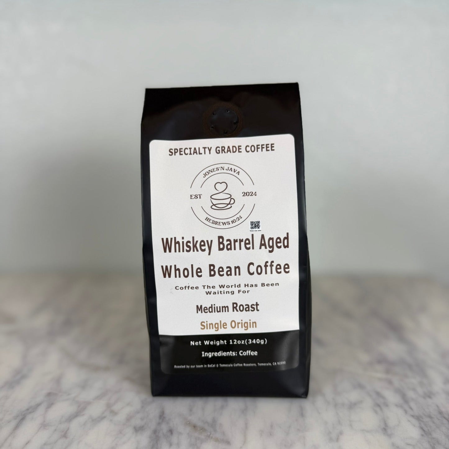 Whiskey barrel aged whole bean coffee medium roast single origin coffee bag by Jones’N Java on marble countertop